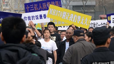 Grieving relatives hold placards as they march towards the Malaysian embassy. Goh Chai Hin / AFP Photo