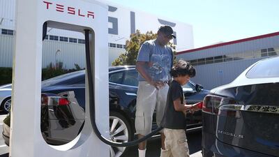 A child plugs a supercharger into a Model S sedan outside of Tesla’s California facility. The superchargers allow owners of the Tesla Model S to charge their vehicles in 20 to 30 minutes for free. Justin Sullivan / Getty Images / AFP