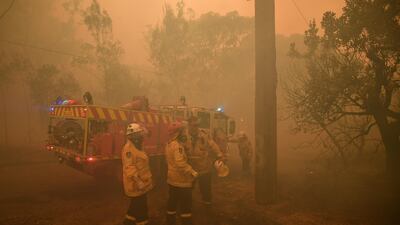 New South Wales (NSW) Rural Fire Service (RFS) and Fire and Rescue NSW crews work to protect a property in Kulnura as the Three Mile fire approaches Mangrove Mountain, Australia. EPA