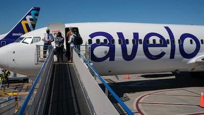Cabin crew wait as passengers board a Boeing Co. 737-800 aircraft operated by Avelo Airlines ahead of the airline's inaugural flight. Bloomberg