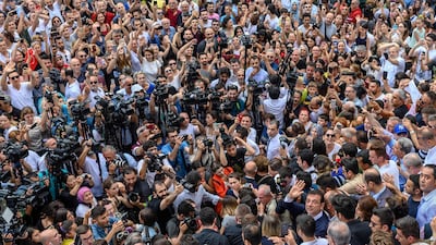 Ekrem Imamoglu, right, waves as he leaves after casting his vote in what has become a test of Turkish democracy as well as the Turkish President's continued popularity at a time of economic trouble. AFP / Bulent Kilic