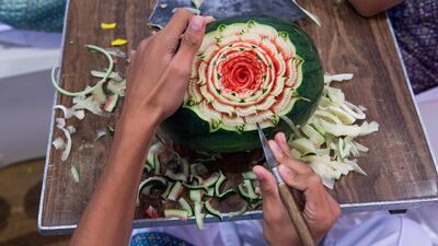 A Thai boy carves floral patterns into a watermelon during a fruit and vegetable carving competition in Bangkok. Robert Schmidt / AFP