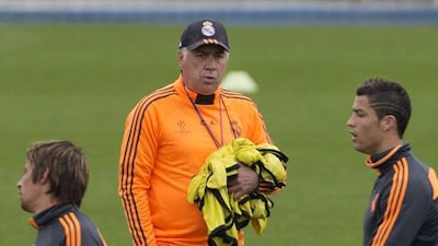 Real's coach Carlo Ancelotti, background watches as Angel Di Maria, left, Gareth Bale, second left, Fabio Coentrao, centre and Cristiano Ronaldo walk past during a training session in Madrid, Spain, Tuesday Oct. 22, 2013. Real Madrid will play Juventus Wednesday in a Group B the Champions League soccer match. (AP Photo/Paul White)