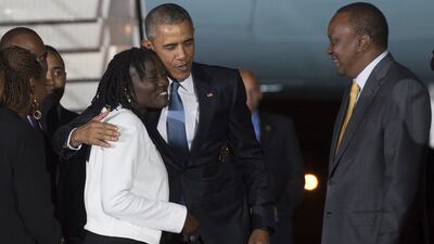 US president Barack Obama greets his half-sister Auma Obama alongside Kenyan president Uhuru Kenyatta upon his arrival at Kenyatta International Airport in Nairobi on July 24, 2015. Saul Loeb / AFP