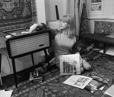 October 1964: Marianne Faithfull playing records at her home in Reading. Getty