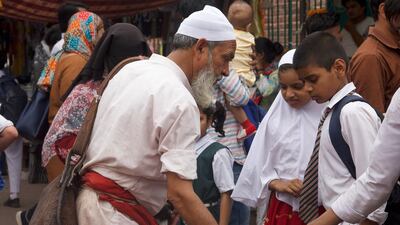 Mr Khaleel offering water to pupils in Delhi