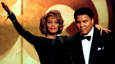 Former boxing great Muhammad Ali is given the Courage Award by singer Whitney Houston at the GQ Men of the Year awards show in New York in this October 21, 1998 file photo. Jeff Christensen / Reuters