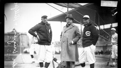 This 1922 photo provided by the Chicago History Museum shows from left, Chicago Cubs baseball player Pete Alexander, team owner William Wrigley Jr, and manager Bill Killefer standing behind a batting practice backstop on the field at Weeghman Park, in Chicago. Weeghman Park was renamed Wrigley Field in 1927. AP / Chicago History Museum