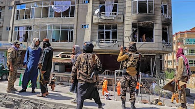 Taliban fighters stand guard at the site of an explosion in front of a Sikh temple, in Kabul on Saturday. EPA