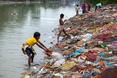 A boy rinsing salvaged waste on the banks of the Ganges Canal at Muradnagar in Uttar Pradesh state. The canal links the Ganges and Yamuna rivers and is used mainly for irrigation. Getty Images