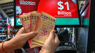 A woman holds up Powerball lottery cards at a store in Florida. AFP