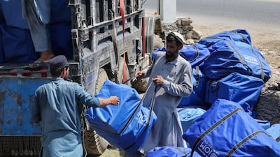 Workers load supplies onto a truck for earthquake victims in Nurgal district, Kunar province. Reuters