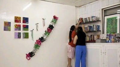 Paraluman Gonzales and Mary Ann Falqueza pick out books supplied to their labour camp by Libraries for Labour Camps, a group set up to take books to worker accommodations in the UAE. ANTONIE ROBERTSON / The National