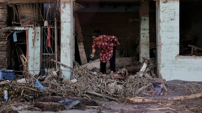A woman searches for her belongings at a damaged shop following flash floods and a mudslide in Trishuli, Nuwakot district, Nepal. Reuters