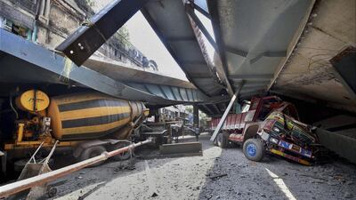 Vehicles were crushed under concrete slabs and metal superstructure after a partially built flyover in Kolkata collapsed on Thursday. Rescuers dug through large chunks of debris in search of commuters trapped beneath the rubble. Swapan Mahapatra / AP Photo