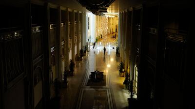 A member of the media stands in the atrium of the Rixos hotel as one half of the hotel experiences a power cut, in Tripoli August 22, 2011. Heavy gun fire rang out near the Tripoli hotel where members of the foreign media are staying, a Reuters correspon???