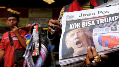 A newspaper seller holds a newspaper with an article about the election of US Republican candidate Donald Trump as president, in Jakarta, Indonesia. The headline reads “Why Trump?” Beawiharta / Reuters