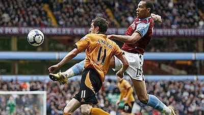 Aston Villa's John Carew, right, battles with Wolves' Stephen Ward during their 2-2 draw yesterday.