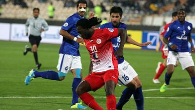 Al Jazira's Felipe Caicedo, centre, fights for the ball against Iran's Esteghlal player Hashem Bekzadeh, right, during their AFC Champions League Group A football match on Tuesday at the Azadi Stadium in Tehran. The match ended in a 2-2 draw. Atta Kenare / AFP / March 18, 2014