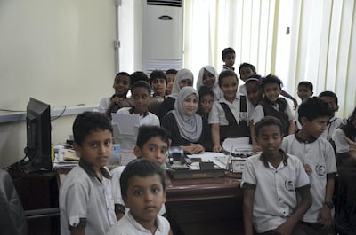 Afrah Mohammed Juma’a Khan poses with children from a local school. Courtesy Saeed Al Batati