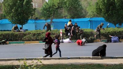 Civilians try to take shelter during the military parade as gunmen started firing. AP Photo