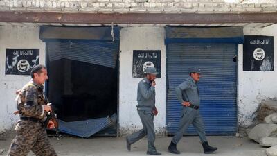 Afghan police walk past ISIL flags, after an operation in the Kot district of Jalalabad province east of Kabul, Afghanistan. Melad Hamedi / AP Photo