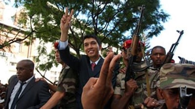 The Madagascar opposition leader Andry Rajoelina, centre, gives the V for victory sign as he parades through the streets of Antananarivo after the president Marc Ravalomanana transferred his powers to Mr Rajoelina following a military operation to topple the regime on the island.