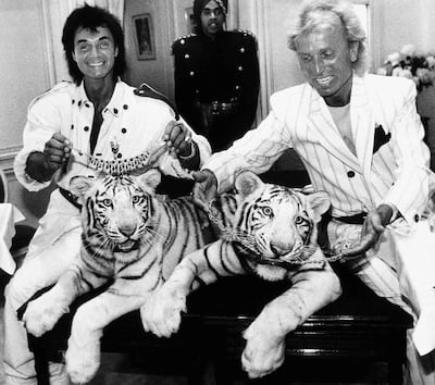 In this June 4, 1987, photo, Las Vegas magicians Roy Horn, left, and Siegfried Fischbacher pose in New York with their rare white tigers. AP Photo