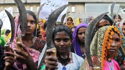 Female peasants hold sickles as they protest against the escalating food crisis in Karachi.