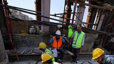 People work on the restoration of tiles in the Baron Palace. EPA