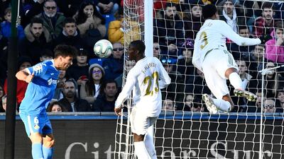 Getafe defender Leandro Cabrera, left, heads the ball as Real Madrid's Eder Militao, right, dives for it. AFP