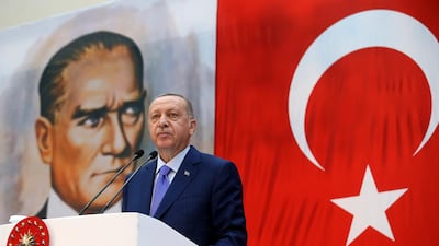 Turkey's President Recep Tayyip Erdogan, backdropped by a poster of modern Turkey's founder Mustafa Kemal Ataturk, speaks during a ceremony in Istanbul, Saturday, Oct. 26, 2019. Presidential Press Service via AP