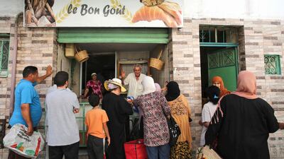 People queue in front of a bakery selling subsidised bread in Tunis' Halfaouine district. AFP