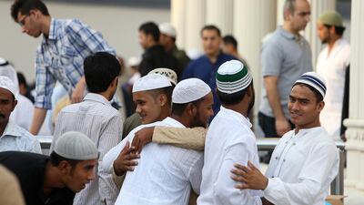 Worshippers greet each other after the Eid prayer at Al Farooq Omar bin Al Khattab Mosque in Dubai. Pawan Singh / The National