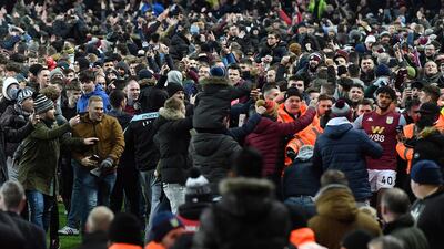 Tyrone Mings tries to leave the pitch after Aston Villa fans celebrate on the pitch. AFP