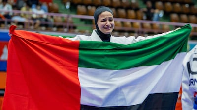 Asma Al Hosani flies the UAE flag after defending her jiu-jitsu title at the Asian Games in Japan. UAEJJF