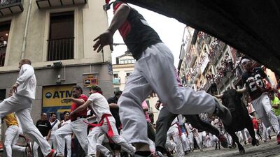 Mozos try to avoid the bulls during the Festival of San Fermin. EPA