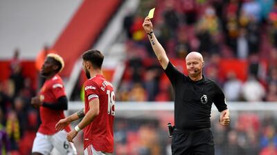 Referee Lee Mason shows a yellow card to United's Bruno Fernandes. AFP