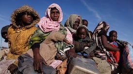 Sudanese refugees ride to a temporary shelter after receiving food at a camp in Chad. Getty Images