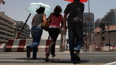 As summer sets in people use umbrellas to protect themselves from the sun's rays in Dubai.