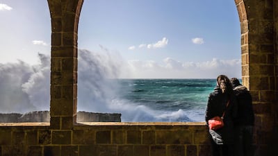 People watch waves crash by the historical Phoenician Wall in the coastal northern Lebanese town of Batroun. AFP