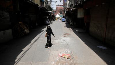 A woman walks on a deserted street in the old quarters of Delhi, India. Reuters