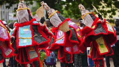 People dress in costumes and dance during the mask festival in Porto Novo, Benin. AP