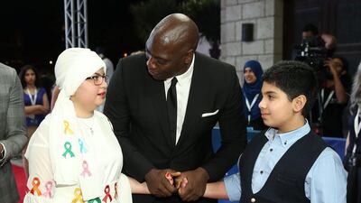 Actor Adewale Akinnuoye-Agbaje with Make-A-Wish Foundation children Sama, left, and Obada, both 13, as they attend the Bilal premiere during day two of the 12th annual Dubai International Film Festival. Neilson Barnard / Getty Images for DIFF