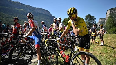 UAE Team Emirates rider Tadej Pogacar, wearing the overall leader's yellow jersey, and the rest of the peloton are brought to a halt by the protestors. AFP