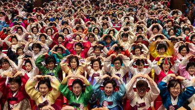 Graduates make heart gestures during their commencement ceremony in Seoul. EPA