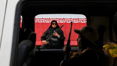 A woman is seen holding a rifle in front of an Iranian flag during a pro-government National Army Day demonstration in Tehran. Getty images