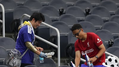 Japan supporters clear the trash on Sunday. AFP