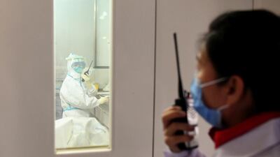 A member of a coronavirus prevention and control team communicates through walkie-talkie with a colleague inside a laboratory at the Ningxia Center for Diseases Prevention and Control in Yinchuan, Ningxia Hui Autonomous Region, China. Reuters