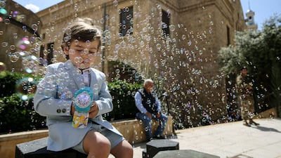A boy plays with a water gun outside a local church in Beirut. Alamy